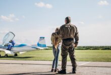 Girl standing with father in front of plane