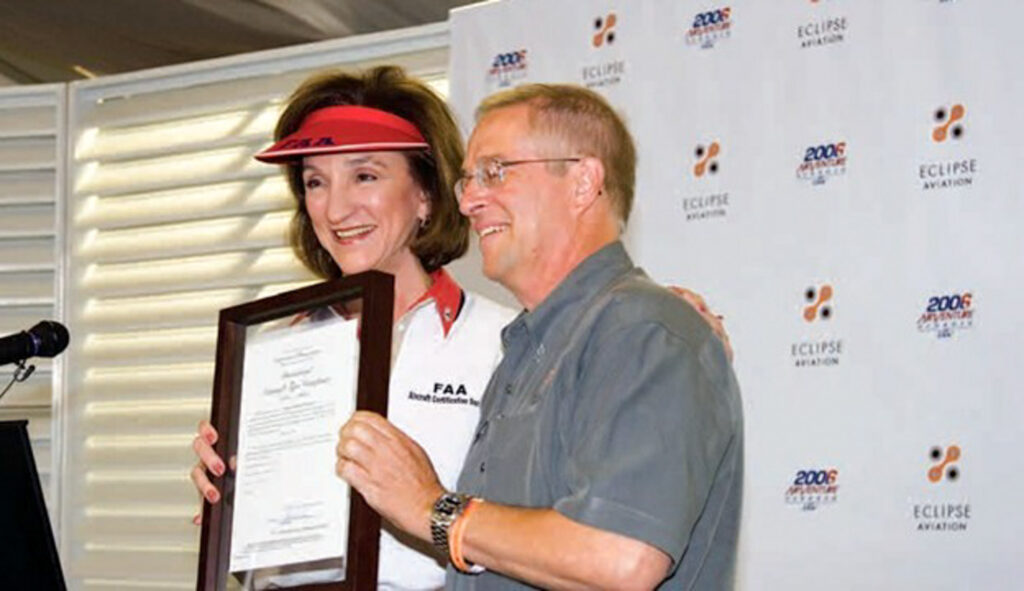 FAA Administrator Marion Blakey presents Vern Raburn with a framed type certificate for one of his Eclipse jets in 2006 [Credit: EAA/Hilary Lawrence]